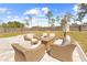 Spacious patio with wicker seating, fire pit, and a fenced backyard, ideal for relaxation and entertainment at 11092 Jenny Wren Rd, Weeki Wachee, FL 34614