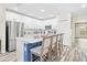 Modern kitchen featuring white cabinets, stainless steel appliances, an island with seating, and wood tile flooring at 11092 Jenny Wren Rd, Weeki Wachee, FL 34614