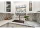 Close-up of kitchen sink with marble countertops and stylish backsplash at 11200 102Nd N Ave # 19, Seminole, FL 33778