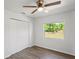 Cozy bedroom with wood-look flooring, a ceiling fan, and a large window offering natural light at 1225 Harvest Home Ct, Ruskin, FL 33570