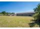 Rear exterior view of the house, highlighting the spacious yard and neutral-toned siding at 1225 Harvest Home Ct, Ruskin, FL 33570