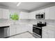 Modern kitchen with stainless steel appliances, white cabinets, and quartz countertops at 1225 Harvest Home Ct, Ruskin, FL 33570