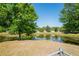 Scenic backyard pond view, framed by lush trees and a glimpse of a chain-link fence at 1225 Harvest Home Ct, Ruskin, FL 33570