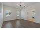 Open-concept dining room featuring hardwood floors, large windows, and a modern chandelier at 1225 Wild Daisy Dr, Plant City, FL 33563