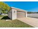 Exterior shot of a detached garage with neutral color, offering extra storage or parking space on a well-kept lawn at 1225 Wild Daisy Dr, Plant City, FL 33563