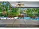 An outdoor covered bar area featuring a tile countertop and adjacent in-ground swimming pool surrounded by lush, tropical landscaping at 1231 Country Club N Rd, St Petersburg, FL 33710