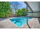 Tranquil backyard pool with privacy fencing and lush tropical landscaping create a serene and private outdoor space at 1231 Country Club N Rd, St Petersburg, FL 33710