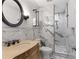 Chic bathroom features marble walls, bronze fixtures, walk-in shower, and designer mirror at 13206 Lewis Raulerson Road, Dover, FL 33527