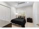 Bright bedroom with white walls, plantation shutters, and dark bedding, creating a serene atmosphere at 13206 Lewis Raulerson Road, Dover, FL 33527