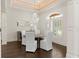 Dining room featuring chandelier, light walls, dark floor and shuttered windows at 13206 Lewis Raulerson Road, Dover, FL 33527
