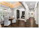 Dining room featuring coffered ceiling, dark floors and view to a study and entry at 13206 Lewis Raulerson Road, Dover, FL 33527