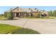Exterior elevation of a home with circular driveway, three car garage, and manicured landscaping at 13206 Lewis Raulerson Road, Dover, FL 33527