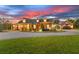 A beautiful home illuminated at dusk, featuring tasteful landscaping and a welcoming driveway at 13206 Lewis Raulerson Road, Dover, FL 33527