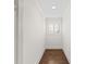 Bright hallway with hardwood floors and white trim showcases natural light from the window at 13206 Lewis Raulerson Road, Dover, FL 33527