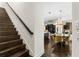 Inviting living room and staircase offer hardwood floors and a glimpse of the dining area with stylish yellow chairs at 13206 Lewis Raulerson Road, Dover, FL 33527