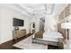 A bright main bedroom showcasing wood floors, a tray ceiling, and a mirrored dresser at 13206 Lewis Raulerson Road, Dover, FL 33527