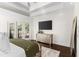 Bright main bedroom with wood floors, tray ceilings, mirrored dresser, and views of the pool at 13206 Lewis Raulerson Road, Dover, FL 33527