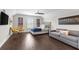 Stylish main bedroom with hardwood floors, ceiling fan, sitting area, and a gray upholstered bed at 13206 Lewis Raulerson Road, Dover, FL 33527