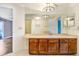 Spacious bathroom featuring a large mirror, cabinetry, and updated lighting at 1331 Abbey Crescent Ln, Clearwater, FL 33759