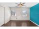 Bright bedroom featuring a ceiling fan, two windows, and beautiful dark hardwood floors at 1331 Abbey Crescent Ln, Clearwater, FL 33759