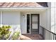 Inviting front entrance with a black door, brick steps, and decorative railing detail at 1331 Abbey Crescent Ln, Clearwater, FL 33759