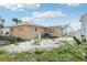 View of the backyard, with sand, vegetation, and the exterior of the house at 15901 Gulf Blvd, Redington Beach, FL 33708