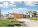 Exterior of a home with a long driveway, palm trees, and a boarded-up garage door under a clear sky at 15901 Gulf Blvd, Redington Beach, FL 33708