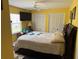 Bedroom featuring bright yellow walls, two closets, and a view of the backyard through a window at 2069 Overbrook Ln, Spring Hill, FL 34606