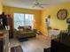 Cozy bedroom featuring bright yellow walls, a comfortable sitting area, and wood laminate floors at 2069 Overbrook Ln, Spring Hill, FL 34606