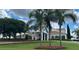 Beautiful clubhouse exterior with manicured lawn and landscaping, palm trees, and blue skies at 2069 Overbrook Ln, Spring Hill, FL 34606