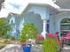 Inviting front patio with red cushioned wicker chairs, potted plants, and an arched entry at 2069 Overbrook Ln, Spring Hill, FL 34606
