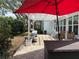 Outdoor patio features a red umbrella, white pergola, brick pavers, and comfortable seating at 2069 Overbrook Ln, Spring Hill, FL 34606