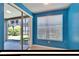 A sun room with tile flooring, large window with blinds, bright blue walls, and sliding glass door to the outside at 2128 River Turia Cir # 2128, Riverview, FL 33578