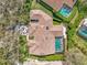 Aerial view of a house with a tile roof, screened pool, and green landscaping at 2136 Pinnacle N Cir, Palm Harbor, FL 34684