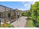 Cozy outdoor area between screened-in patio and yard showcases a landscaped walkway at 2136 Pinnacle N Cir, Palm Harbor, FL 34684