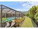 A view showing a screened-in patio with a pool and an adjacent landscaped brick walkway at 2136 Pinnacle N Cir, Palm Harbor, FL 34684