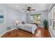 Bright bedroom with wood floors, ceiling fan, and a sunlit window with lush outdoor views at 2136 Pinnacle N Cir, Palm Harbor, FL 34684