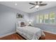Cozy bedroom with hardwood floors, a ceiling fan, and a window with plantation shutters at 2136 Pinnacle N Cir, Palm Harbor, FL 34684