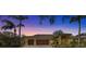 Exterior of a beautiful house at dusk, showing the warm glow of the front lights at 2136 Pinnacle N Cir, Palm Harbor, FL 34684