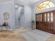 Inviting foyer with travertine floors, decorative mirror, and attractive double front doors at 2136 Pinnacle N Cir, Palm Harbor, FL 34684