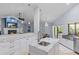 Open concept kitchen with white cabinets, marble countertops, and a view into the living room at 2136 Pinnacle N Cir, Palm Harbor, FL 34684