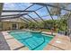 Inviting screened-in pool and spa with brick patio and lush landscaping create a private oasis at 2136 Pinnacle N Cir, Palm Harbor, FL 34684
