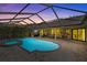 Outdoor pool and spa with a screened enclosure, brick patio, and equipped kitchenette at 2136 Pinnacle N Cir, Palm Harbor, FL 34684