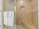 Luxurious tiled shower featuring glass doors, a built-in bench, and a shower niche at 2136 Pinnacle N Cir, Palm Harbor, FL 34684