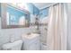 Bright blue bathroom featuring a tiled shower, vanity, and large mirror, creating a clean and refreshing space at 2410 E Palifox St, Tampa, FL 33610