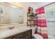 Functional bathroom featuring a vanity, toilet, and shower-tub combination with colorful accents at 2410 E Palifox St, Tampa, FL 33610