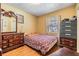 Cozy bedroom with warm tones, a patterned bedspread, and matching wood furniture at 2410 E Palifox St, Tampa, FL 33610
