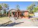 Charming red brick home featuring a cozy front porch and well-maintained landscaping, offering curb appeal at 2410 E Palifox St, Tampa, FL 33610