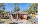 Charming red brick home featuring a cozy front porch and well-maintained landscaping, offering curb appeal at 2410 E Palifox St, Tampa, FL 33610