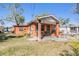 Quaint red brick home with a covered front porch, surrounded by a lush yard for relaxed outdoor living at 2410 E Palifox St, Tampa, FL 33610